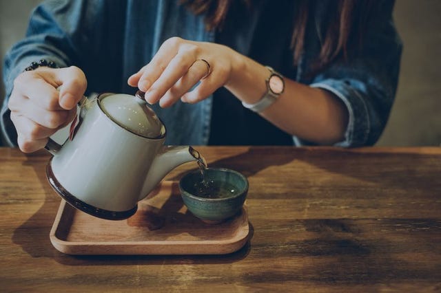 vrouw schenkt groene thee in