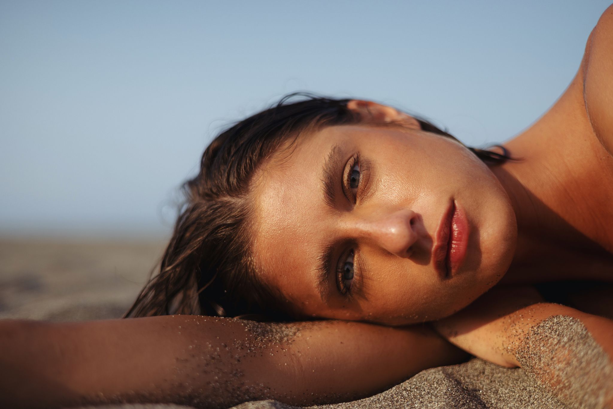 kobieta ciesząca się relaksującym dniem na piaszczystej plaży podczas słonecznego popołudnia