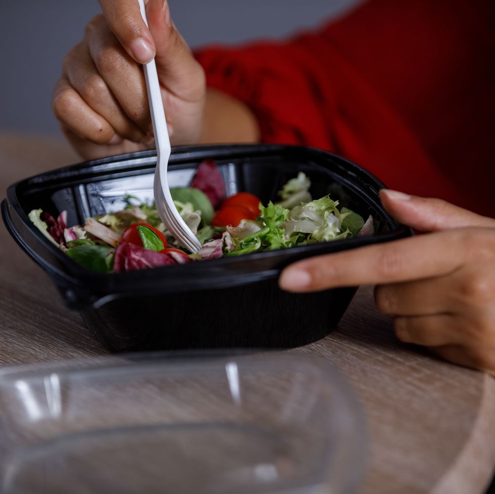woman enjoying a takeaway salad for lunch