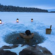woman enjoying cold baths in a ice hole, lapland
