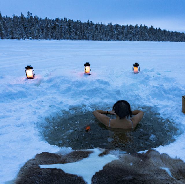 woman enjoying cold baths in a ice hole, lapland