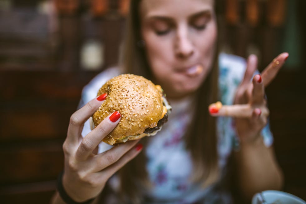 mujer devorando una hamburguesa