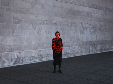 woman entangled with neon wires against urban marble background