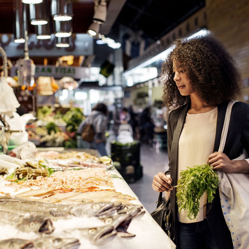 staycation ideas - Woman examining fish in market