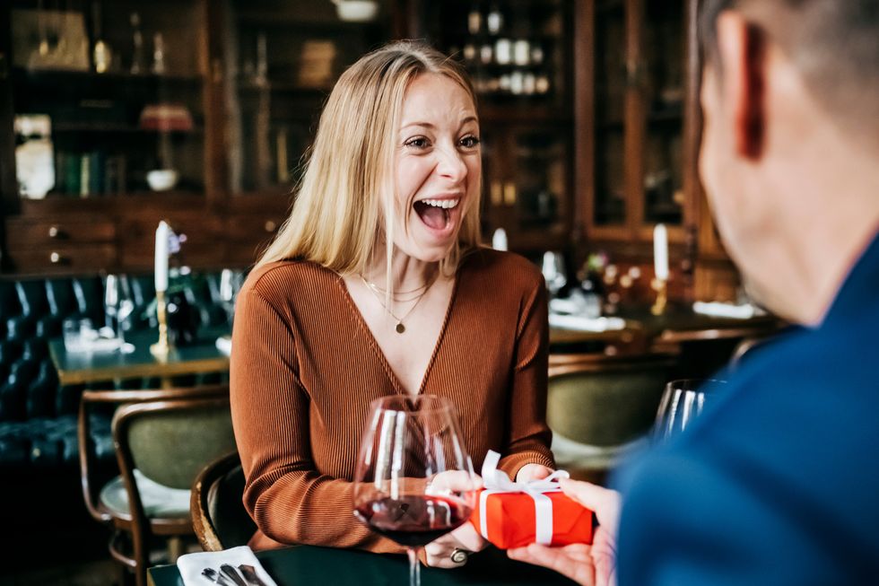 woman excited to receive gift in restaurant