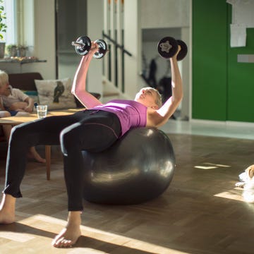 vrouw doet oefeningen thuis op een fitnessbal