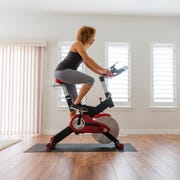 Woman Exercising on Spin Bike in Home woman exercising on spin bike in home