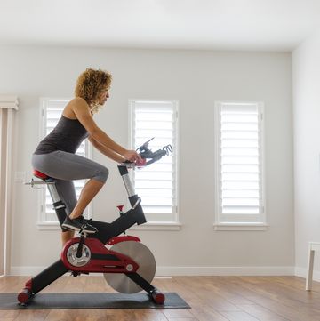 woman exercising on spin bike in home
