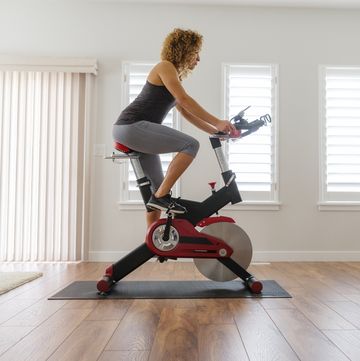 woman exercising on spin bike in home