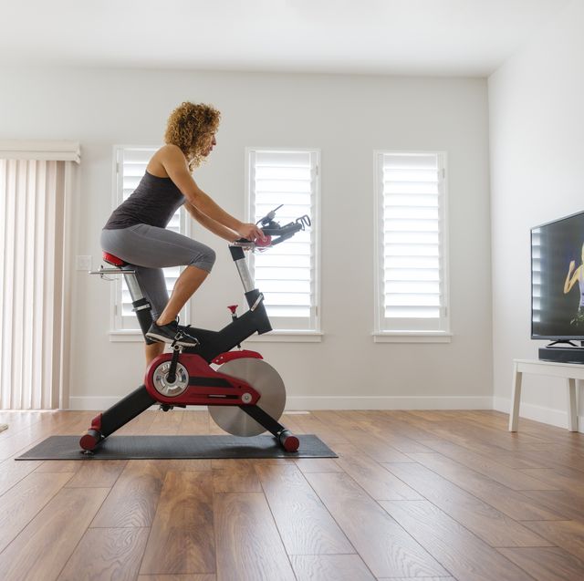 woman exercising on spin bike in home