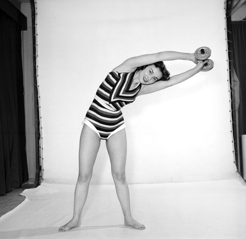 keep fit woman exercising with dumb bells 1960