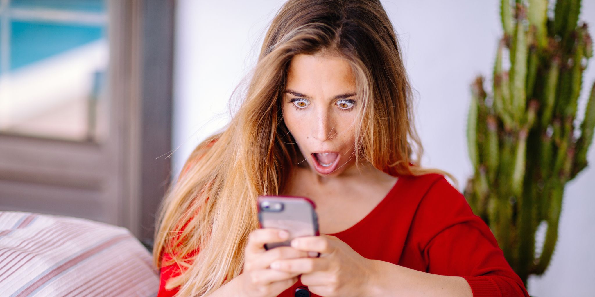 Woman feeling big surprise checking phone