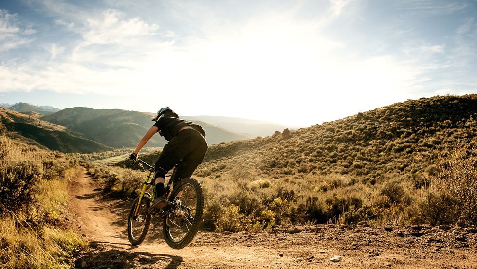 persona che va in bici nera in un sentiero