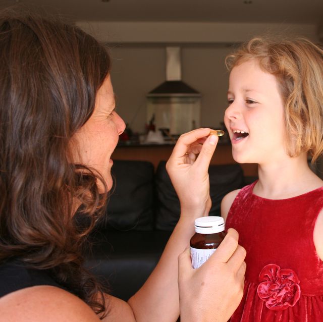 a woman giving her child supplements