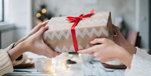 Woman giving her friend a wrapped Christmas gift