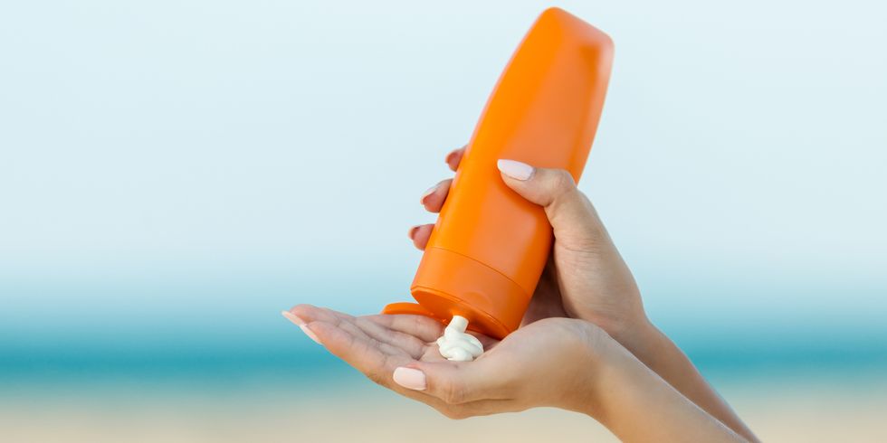woman hand apply sunscreen on the beach