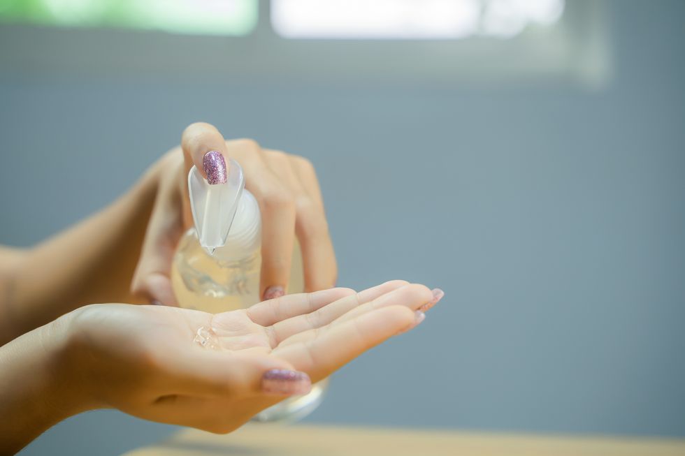 woman hand using alcohol wash gel for cleaning sanitize gel pump dispenser
