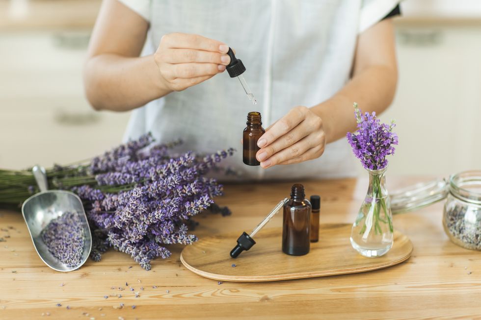 woman hands holding pipette of essential lavender oil