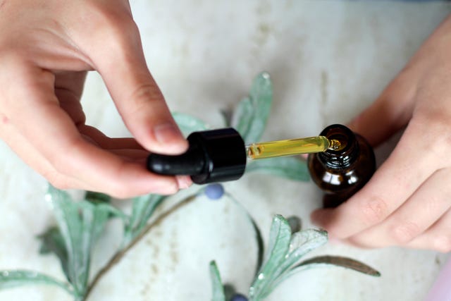 woman hands holding pipette of essential oil