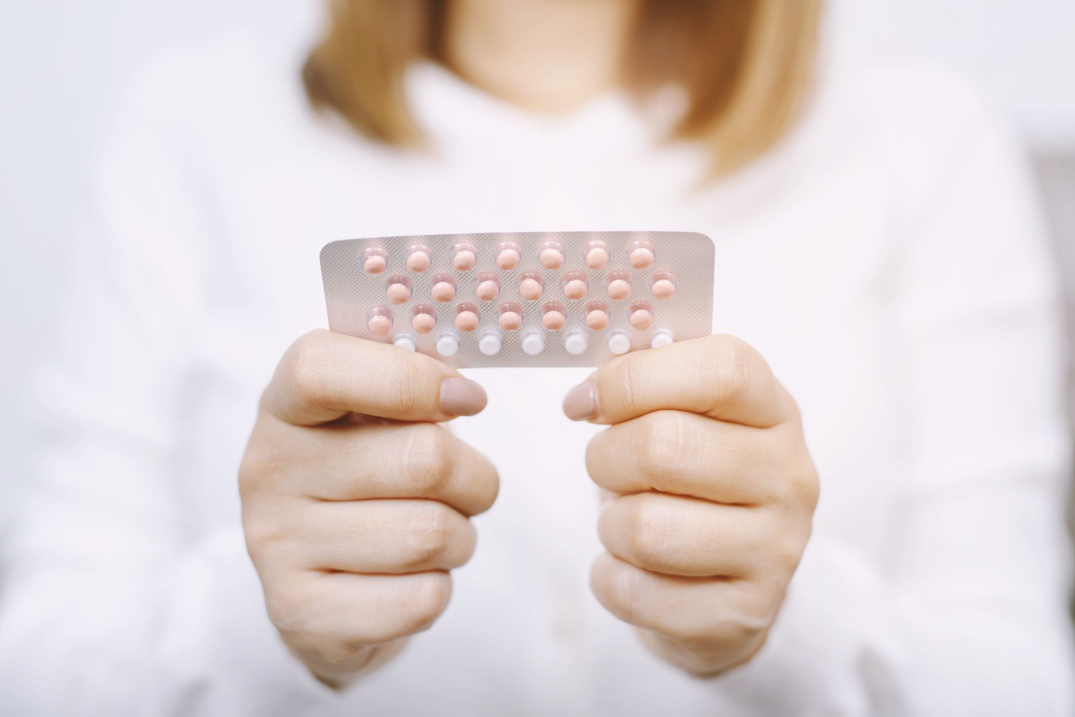 woman hands opening birth control pills in hand eating contraceptive pill contraception reduces childbirth and pregnancy concept