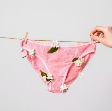 woman hangs underwear with flowers on clothesline, concept content for feminist blog, poster about women's health