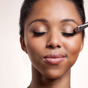 woman having eyeshadow applied on her face