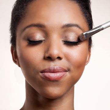 woman having eyeshadow applied on her face
