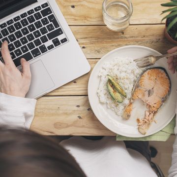 woman having lunch and using laptop