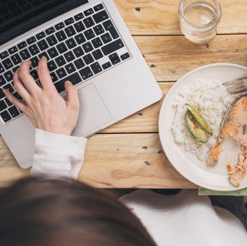 woman having lunch and using laptop