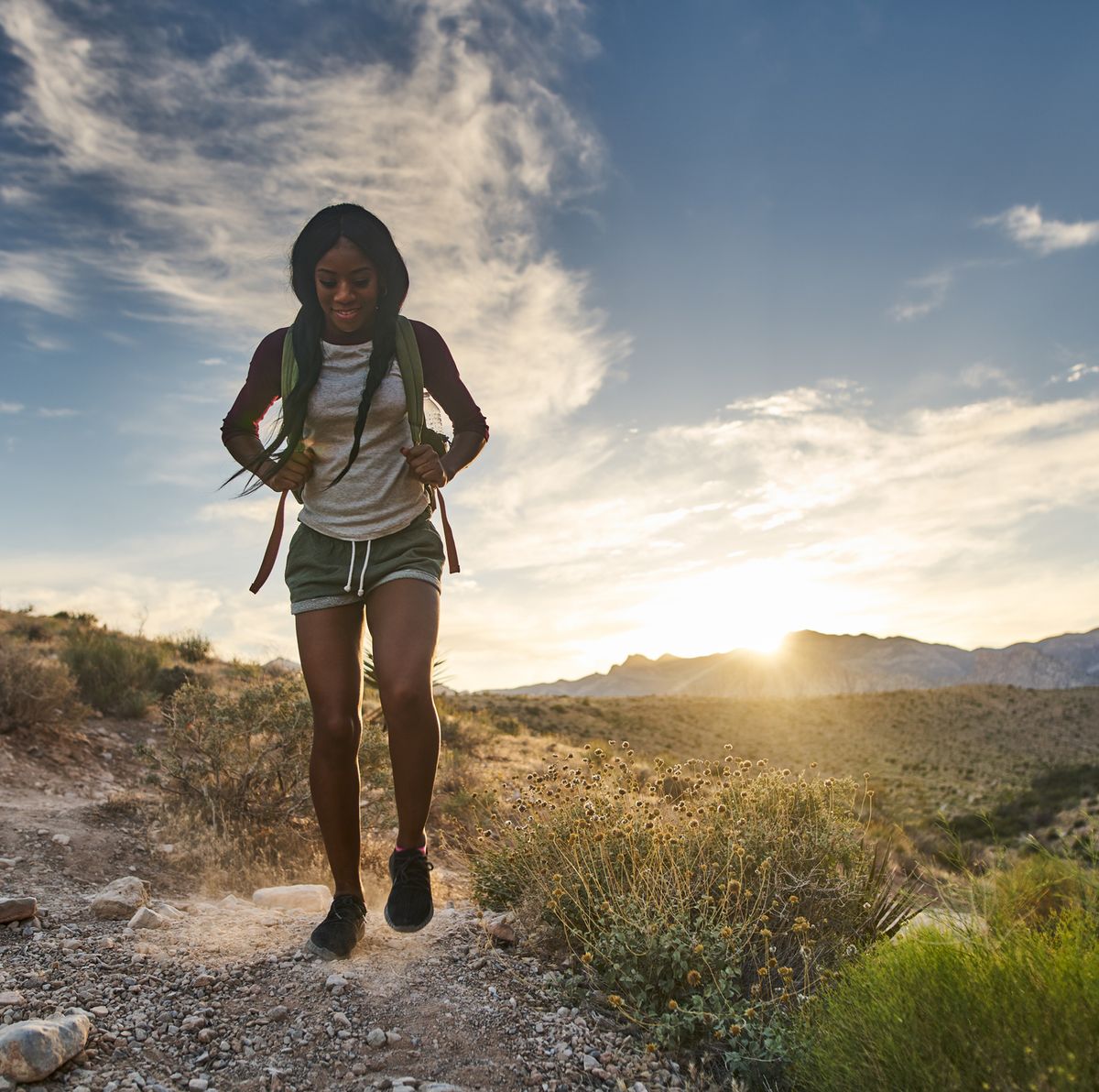 https://hips.hearstapps.com/hmg-prod/images/woman-hiking-at-red-rock-canyon-during-sunset-with-royalty-free-image-1601478369.jpg?crop=0.671xw:1.00xh;0.137xw,0&resize=1200:*