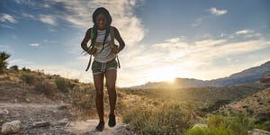 woman hiking at red rock canyon during sunset with backpack