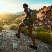 woman hiking at red rock canyon during sunset with backpack