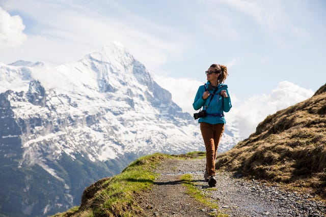 mujer bien equipada con zapatillas de trekking disfrutando de la montaña