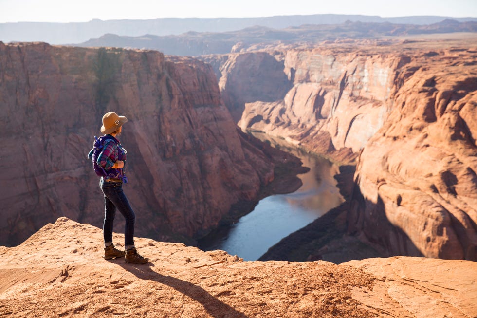 a woman hiking on the edge of a scenic overlook