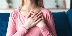 woman hold hand folded close to heart in peaceful sign