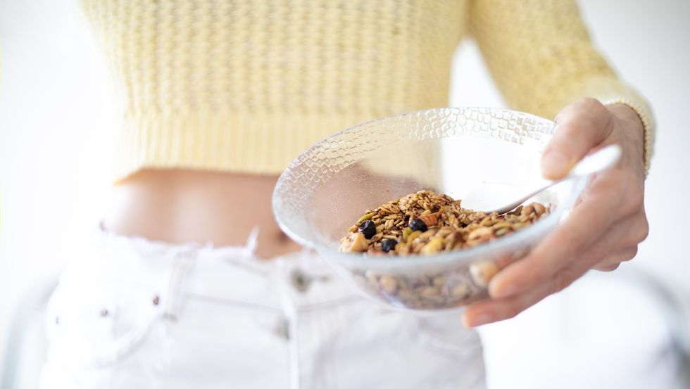 A woman holding a bowl of granola
