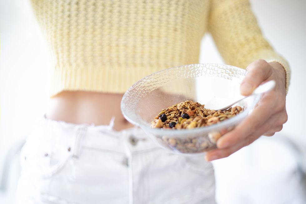 A woman holding a bowl of granola