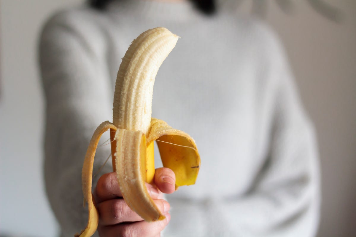woman holding a peeled banana