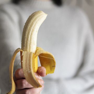 woman holding a peeled banana