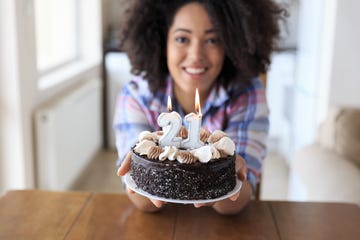 woman holding birthday cake with candles