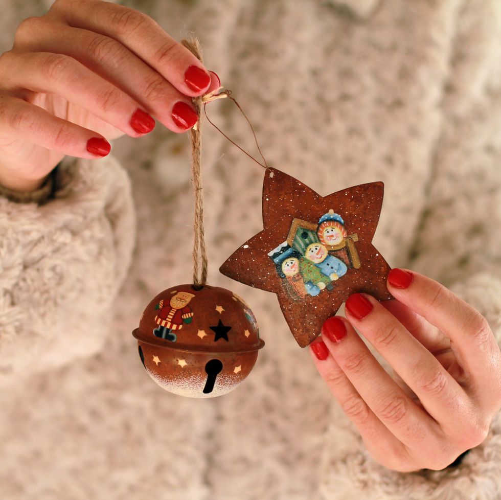 woman holding star and bell shaped ornaments