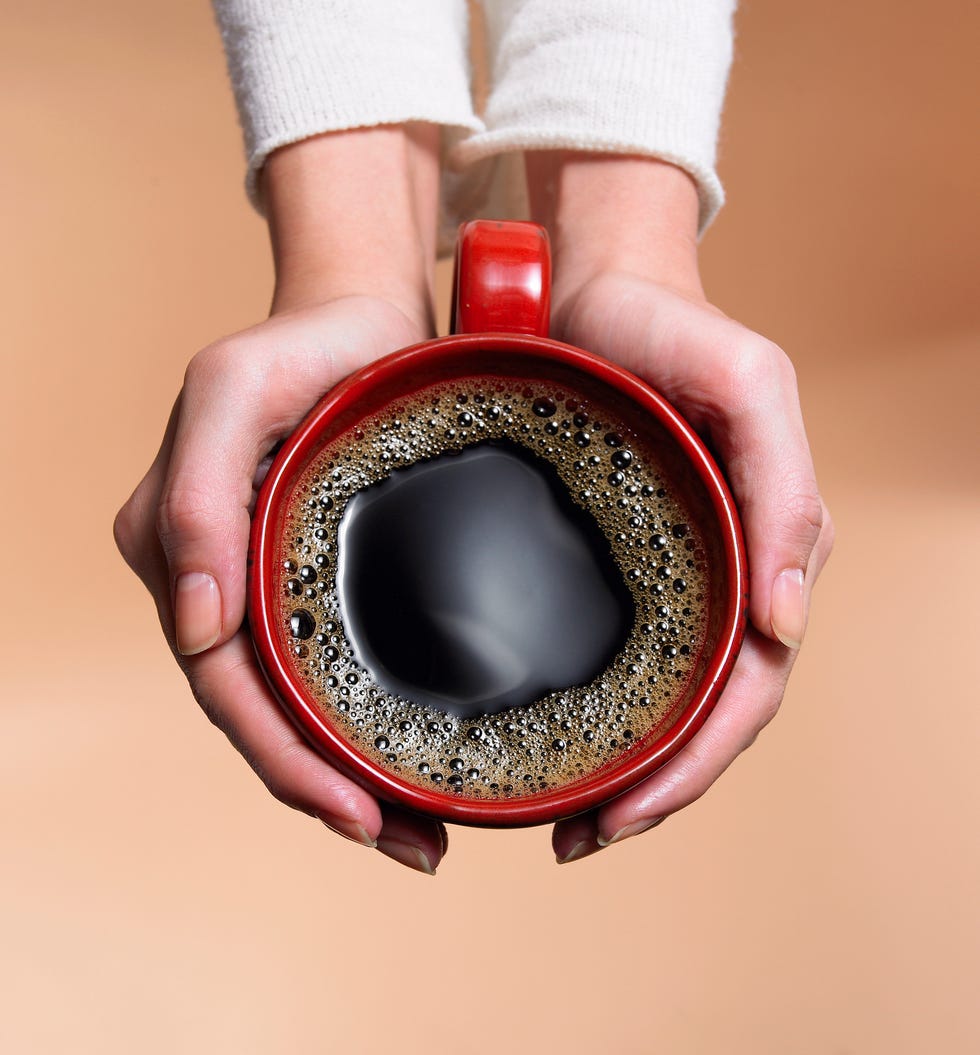 "woman holding coffee cup, close up, overhead view"