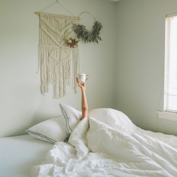 mujer con taza de cafe en la cama