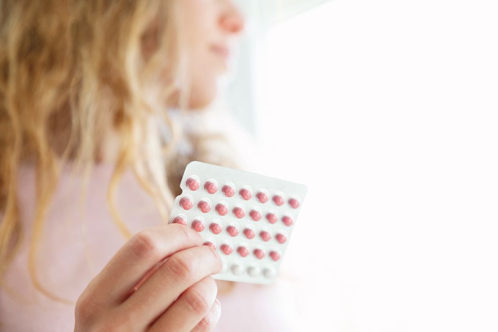 woman holding contraceptive pill