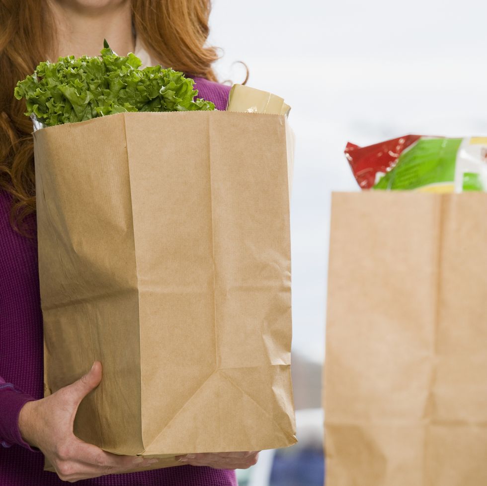 Woman holding groceries at supermarket check-out