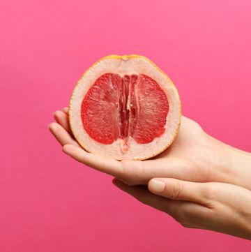 grapefruit in hand op roze achtergrond