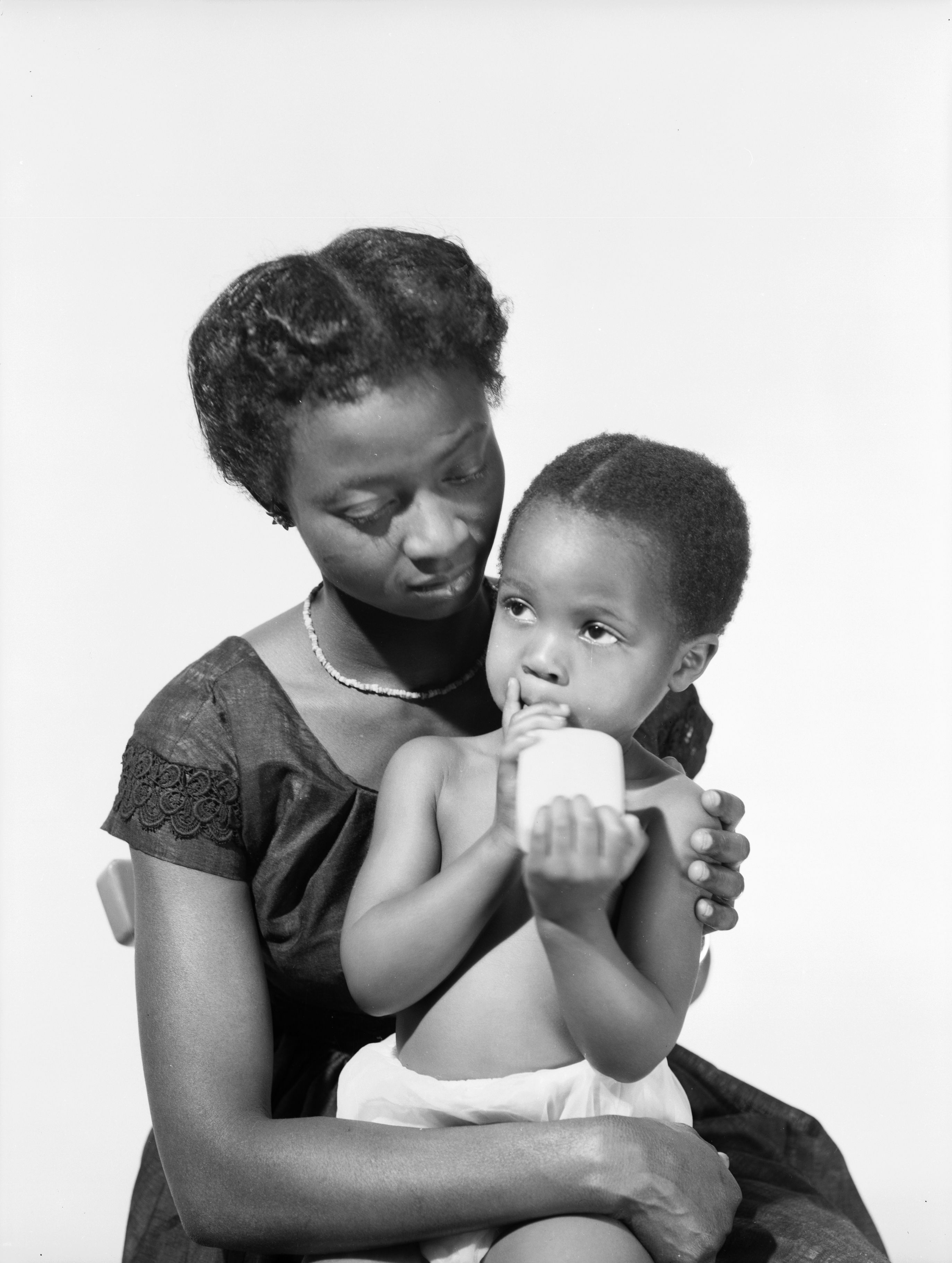A woman in a black dress holding a black bag photo – With child