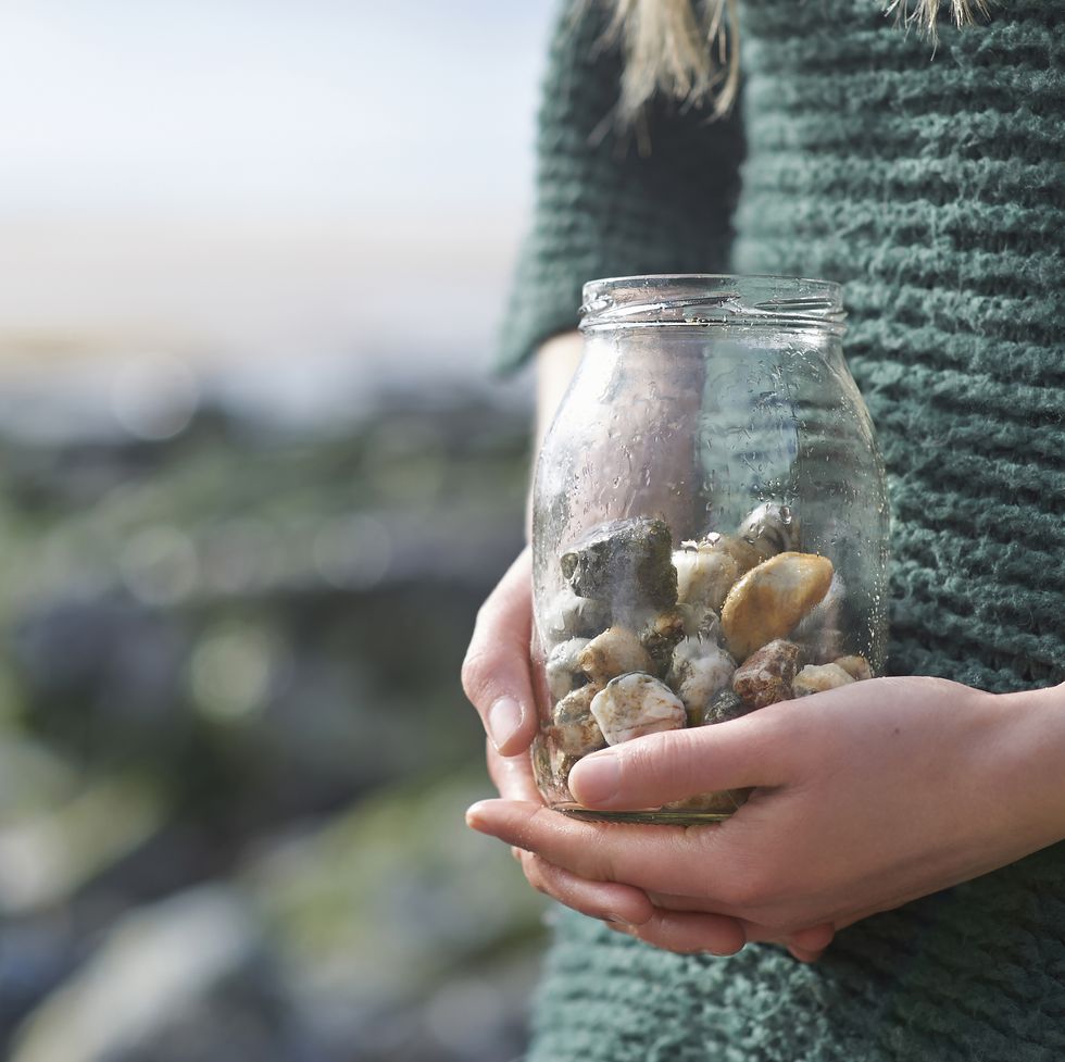 woman holding jar of pebbles