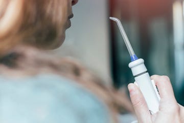 woman holding oral irrigator