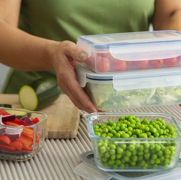 woman holding plastic airtight food containers filled with vegetables ready for be stored in the refrigerator